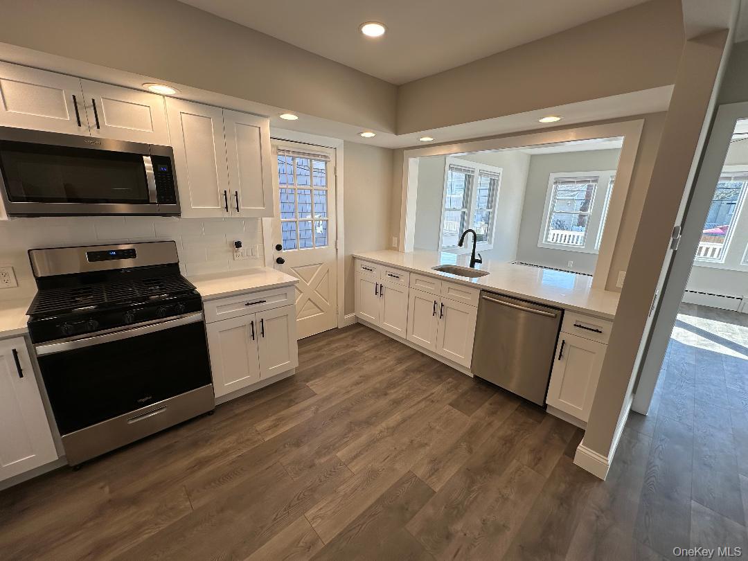 84 Rochester Avenue, Unit MAIN Long Beach, NY 11561 - Photo 9 of 27 a large kitchen with a stove top oven and sink