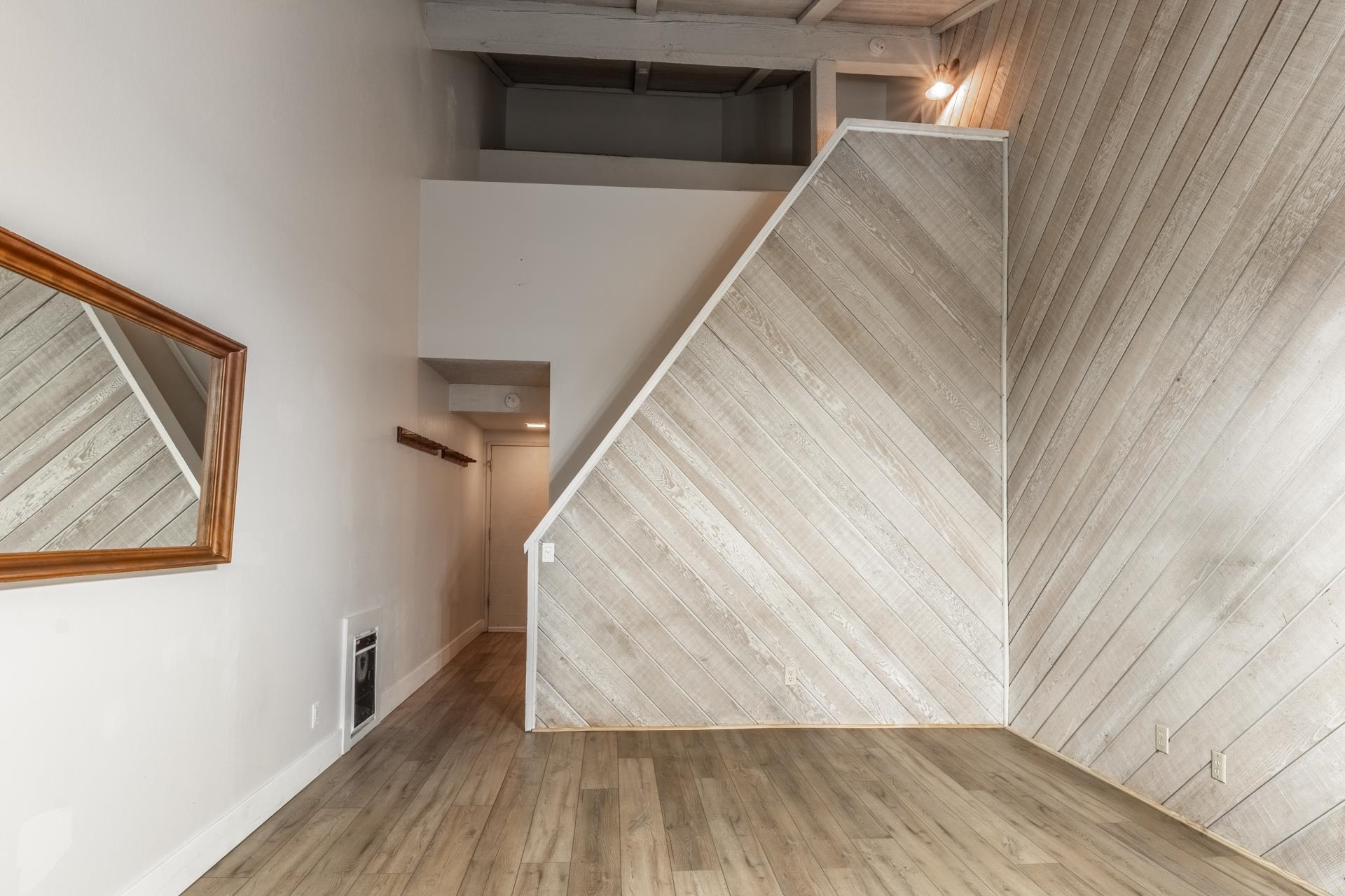 362 Old Mammoth Road, Unit 59 Mammoth Lakes, CA 93546 - Photo 8 of 35 Wood-finish flooring, accent wall with diagonal wood paneling, white painted walls, exposed ceiling beams, and recessed lighting