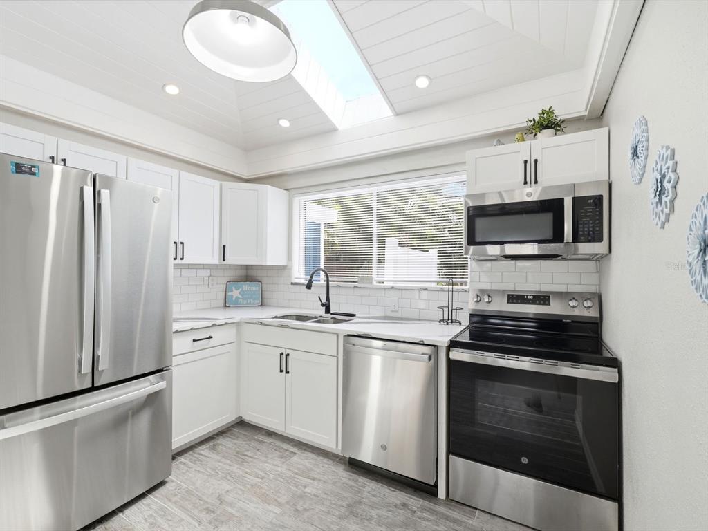 1207 1st Street Indian Rocks Beach, FL 33785 - Photo 13 of 60 a kitchen with a sink stove and microwave