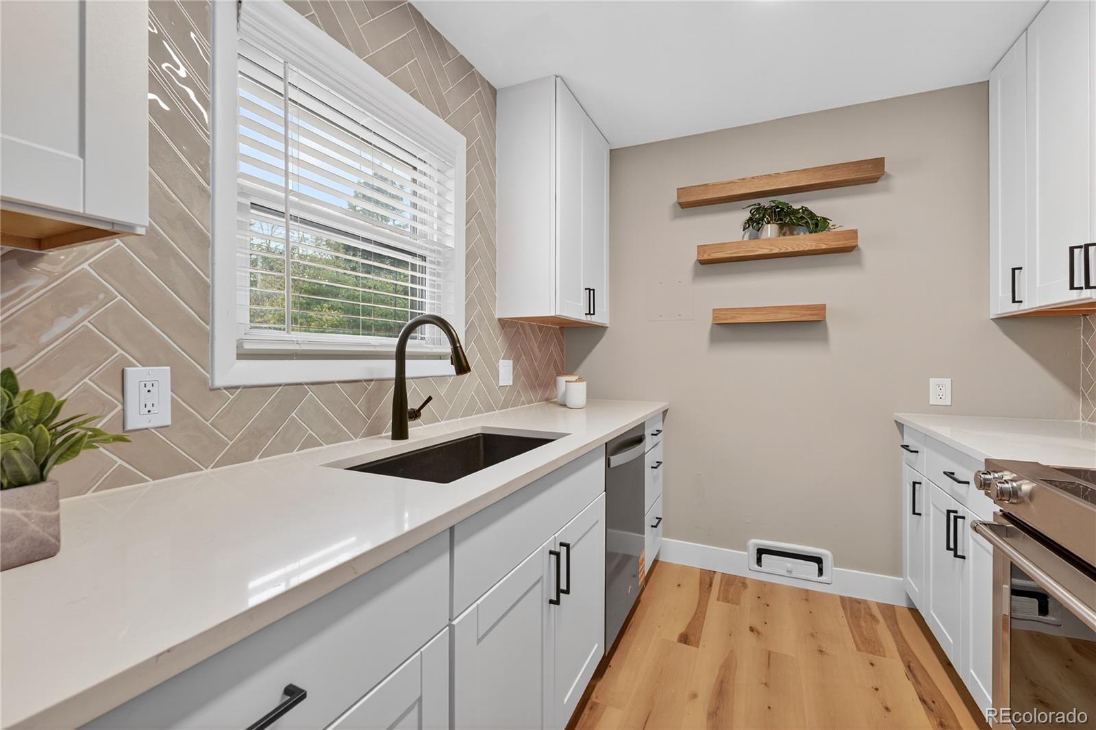 4910 East Missouri Avenue Denver, CO 80246 - Photo 13 of 42 a kitchen with a sink and wooden floor