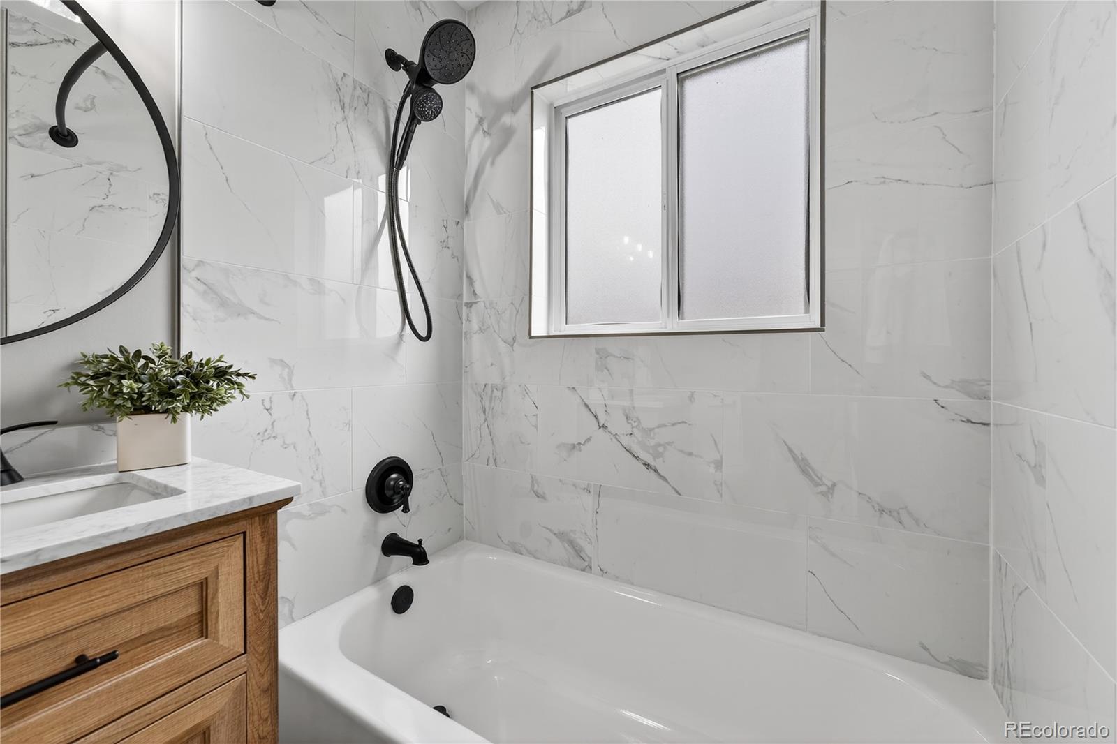 4910 East Missouri Avenue Denver, CO 80246 - Photo 26 of 42 a bathroom with a bath tub a sink and a window
