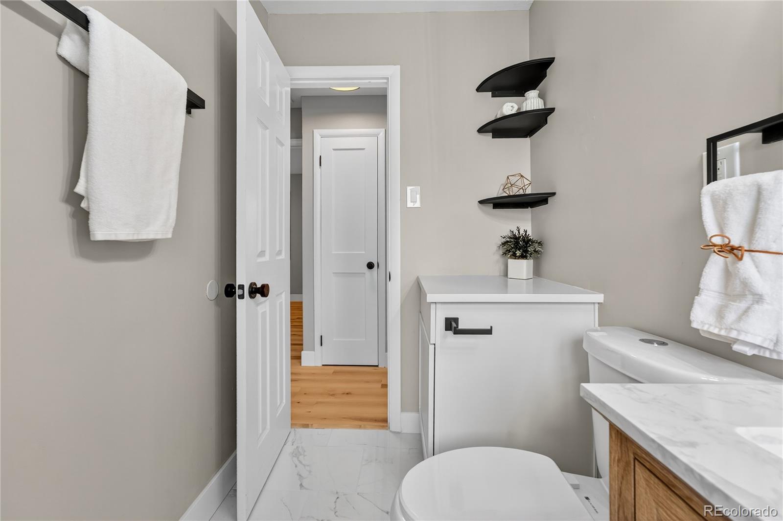 4910 East Missouri Avenue Denver, CO 80246 - Photo 27 of 42 a bathroom with a toilet a sink and mirror