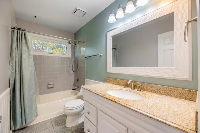 a bathroom with a granite countertop sink toilet and shower