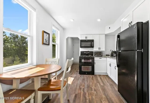 a kitchen with stainless steel appliances a refrigerator stove and table