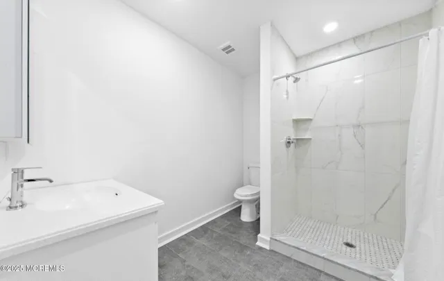 a bathroom with a shower toilet and sink