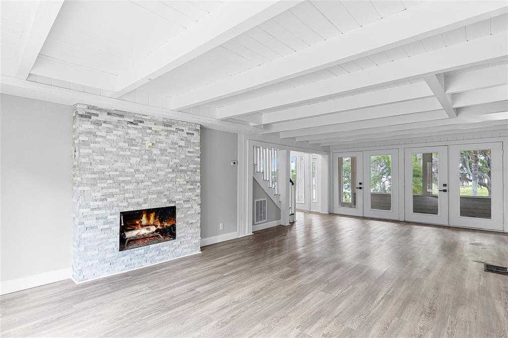 311 East 8th Avenue Windermere, FL 34786 - Photo 14 of 59 a view of an empty room with wooden floor fireplace and a window
