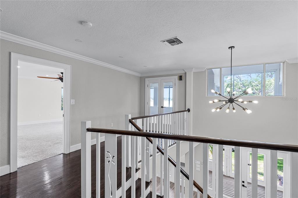 311 East 8th Avenue Windermere, FL 34786 - Photo 30 of 59 a view of a hallway with wooden floor and chandelier