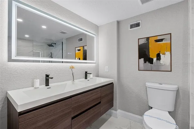 a bathroom with a sink a toilet and shower