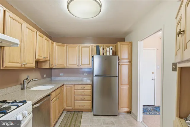 a kitchen with a refrigerator sink and cabinets
