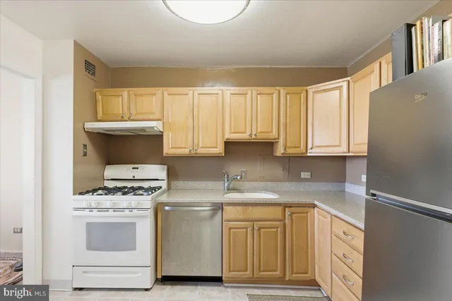 a kitchen with granite countertop white cabinets and white appliances