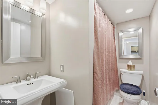 a bathroom with a sink mirror vanity and toilet