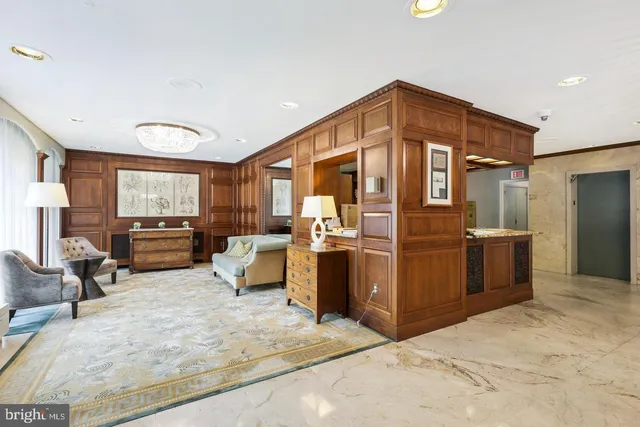 a living room with furniture a large window and kitchen view