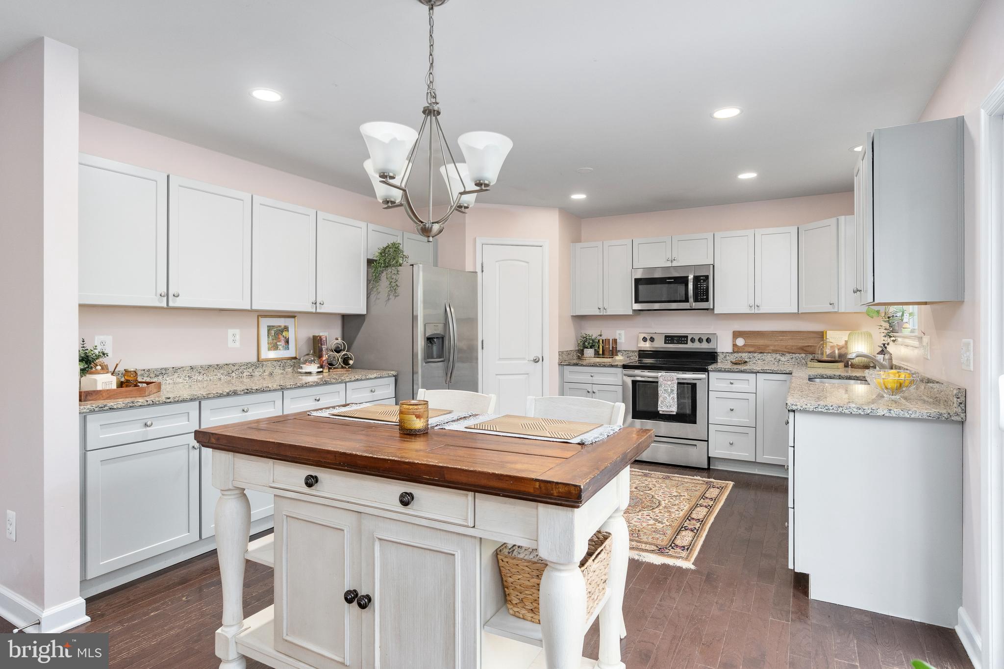 109 12th Street Colonial Beach, VA 22443 - Photo 11 of 33 a kitchen with stainless steel appliances granite countertop a sink a stove a refrigerator cabinets and chairs