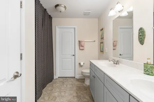 a bathroom with a sink a light fixture and a mirror
