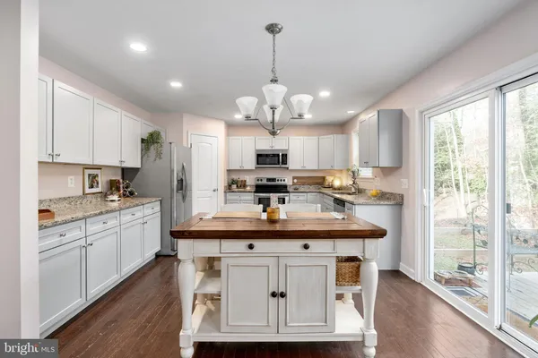 a kitchen with kitchen island granite countertop a sink stove and refrigerator