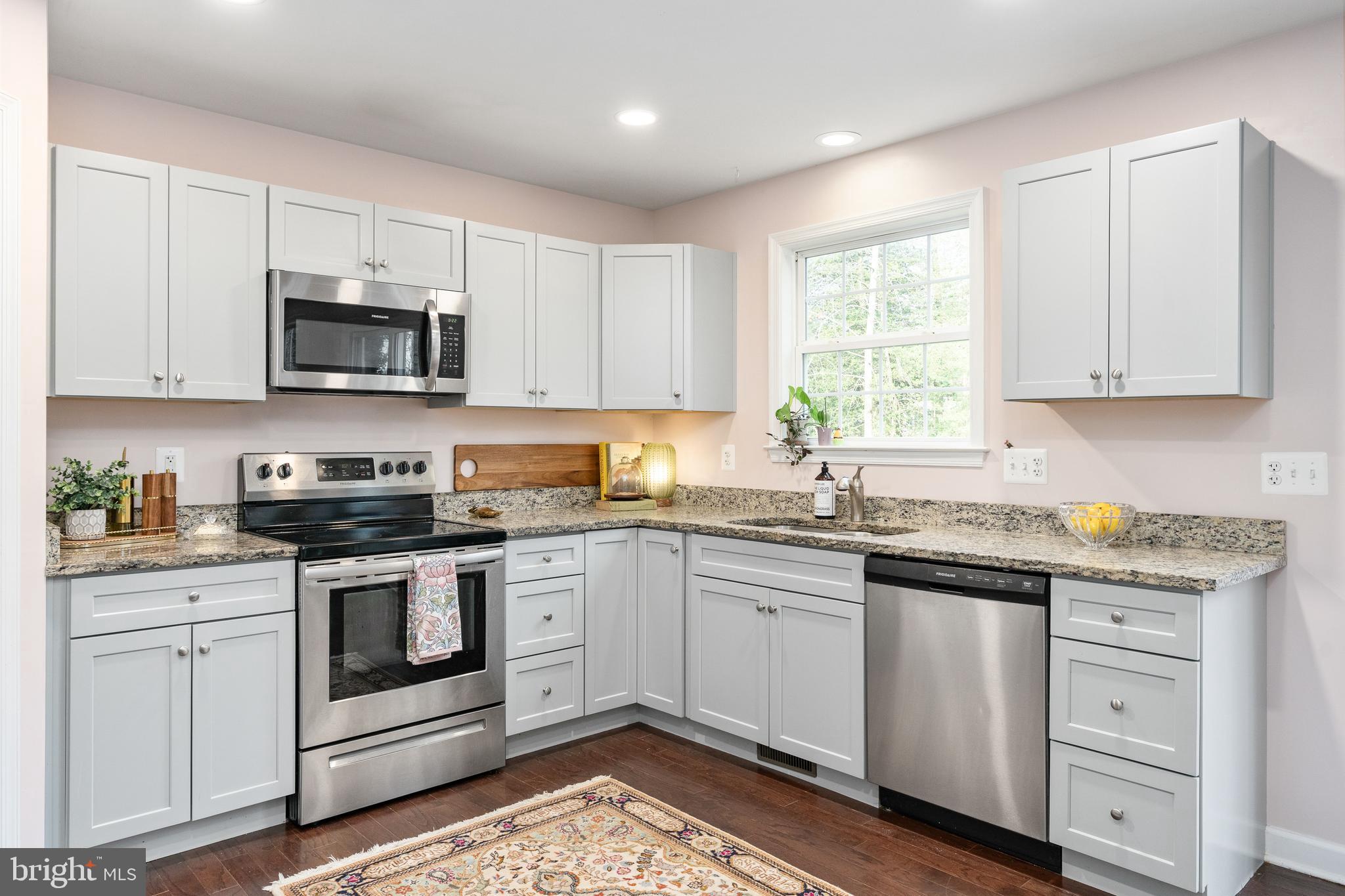 109 12th Street Colonial Beach, VA 22443 - Photo 10 of 33 a kitchen with granite countertop white cabinets white stainless steel appliances and a sink