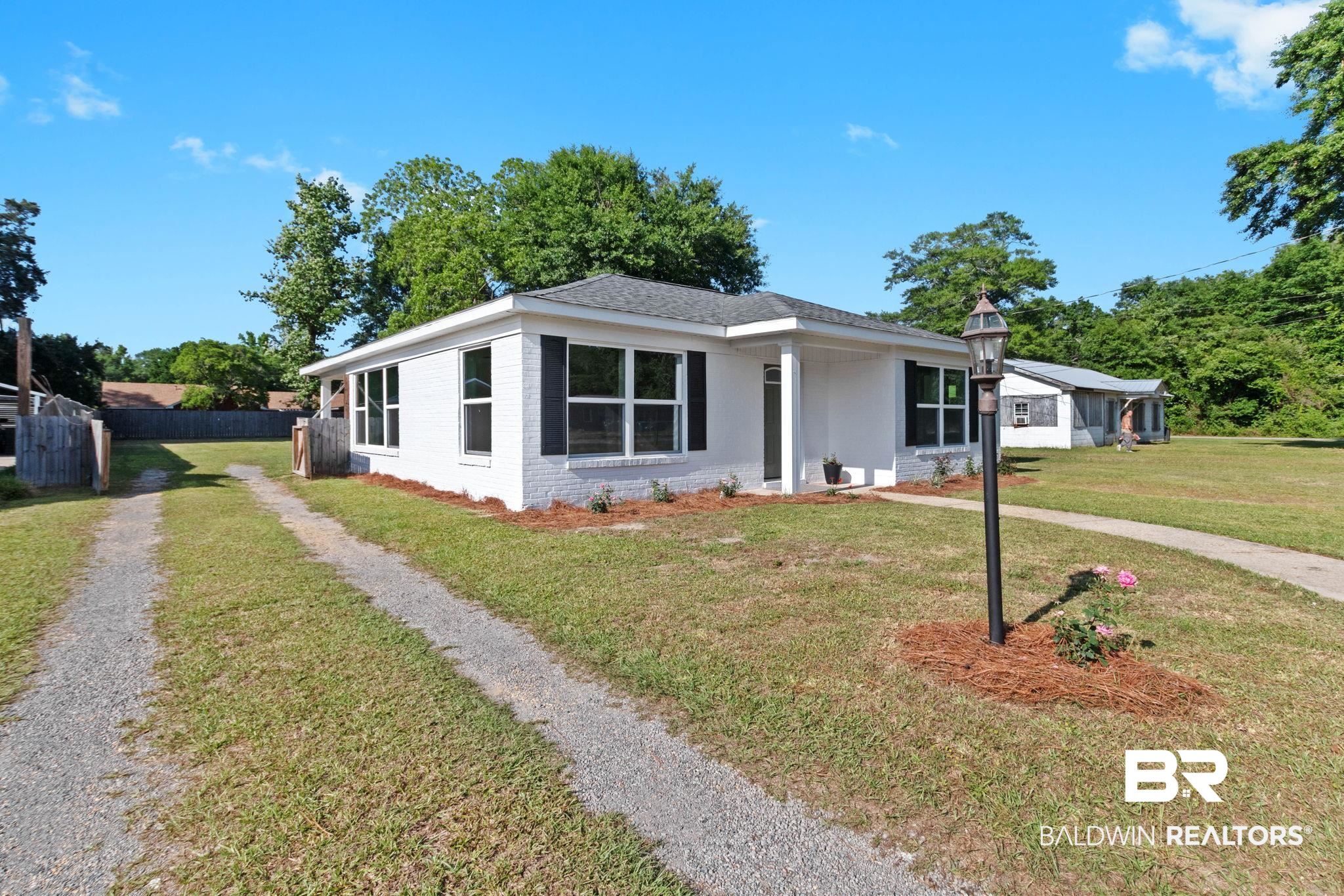 311 Cloverdale Road Atmore, AL 36502 - Photo 63 of 63 White brick exterior featuring a dark asphalt shingle roof