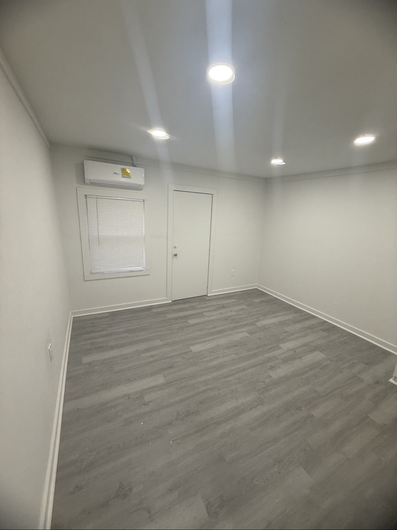 1009 Thomas Boulevard Port Arthur, TX 77640 - Photo 5 of 14 an empty room with wooden floor and windows