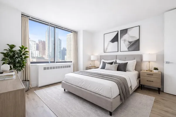 a bedroom with a large bed and a window with outer view