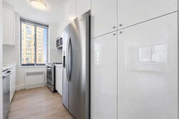 a view of a kitchen with a refrigerator and window