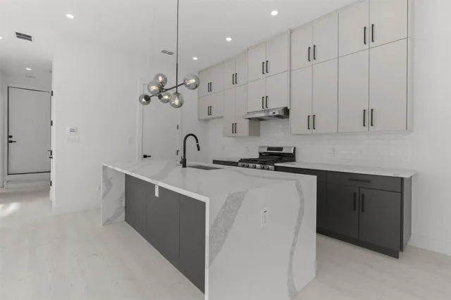 a kitchen with kitchen island a sink stainless steel appliances and cabinets