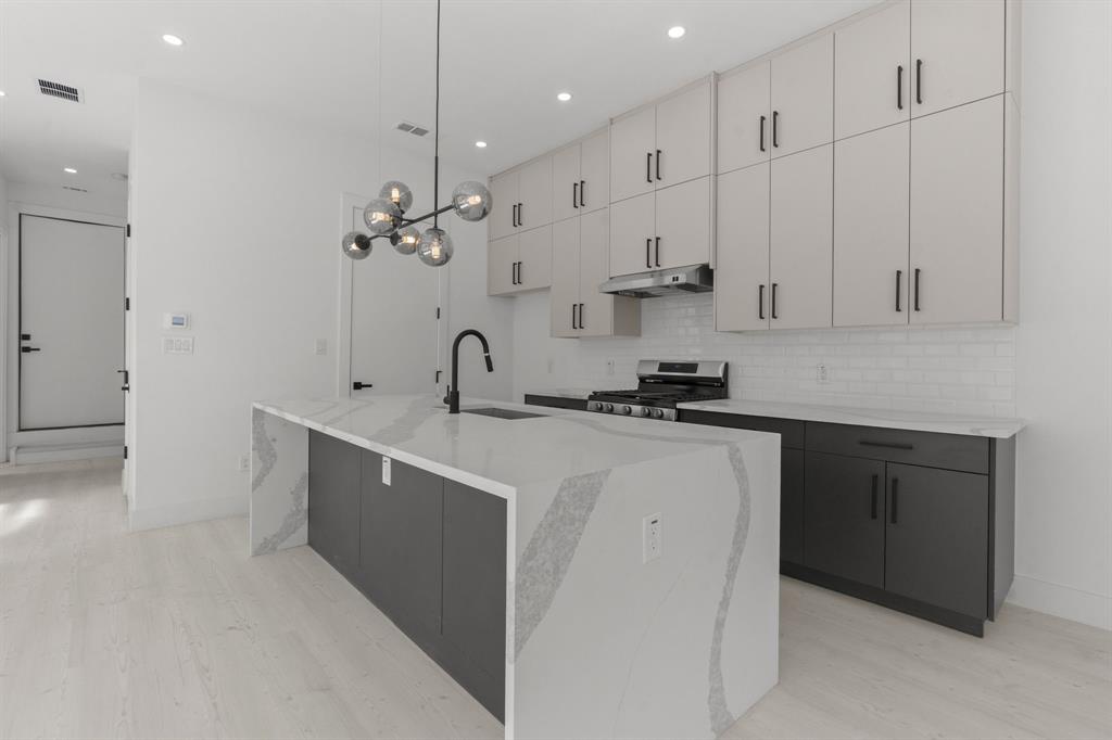 1849 Pollard Street Dallas, TX 75208 - Photo 2 of 10 a kitchen with kitchen island a sink stainless steel appliances and cabinets