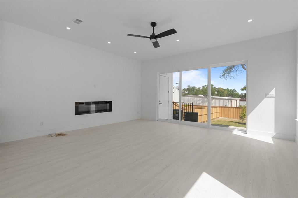 1849 Pollard Street Dallas, TX 75208 - Photo 3 of 10 a view of a livingroom with a ceiling fan a ceiling fan and windows