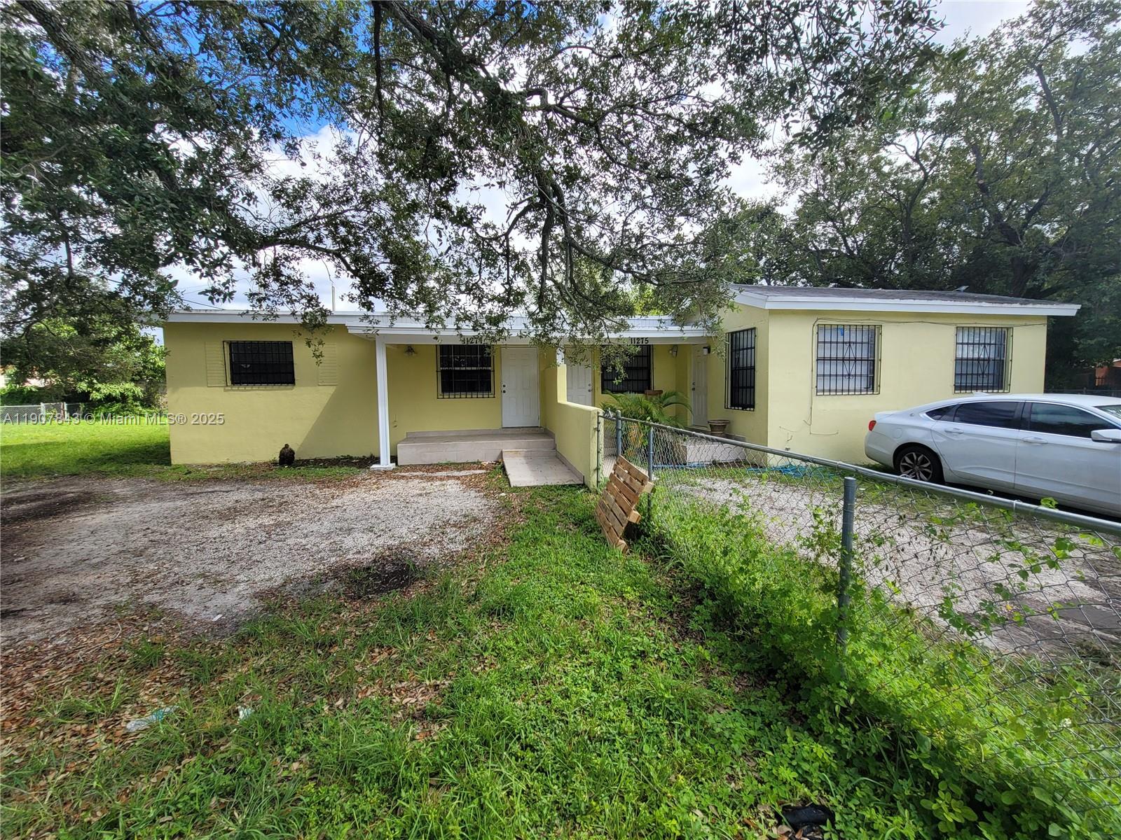 a front view of house with yard and trees around
