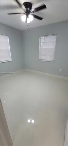 en empty room with windows and ceiling fan