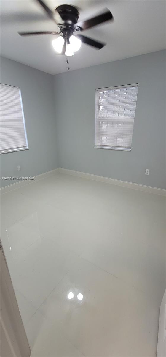 11275 Northwest 17th Avenue Miami, FL 33167 - Photo 14 of 21 en empty room with windows and ceiling fan