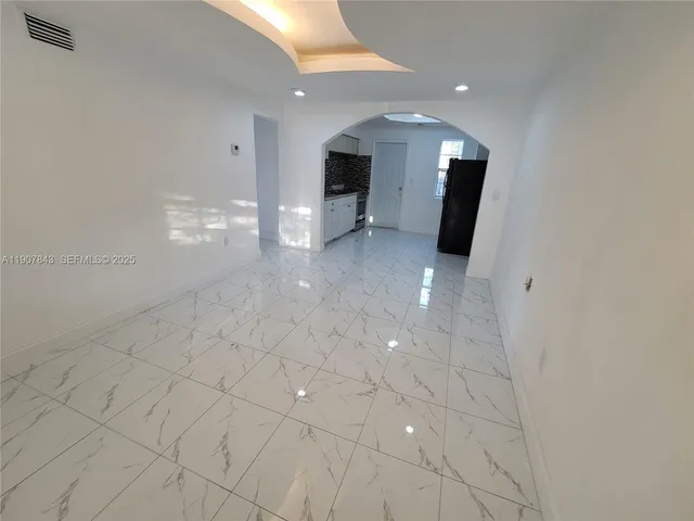 an empty room with windows and entrance