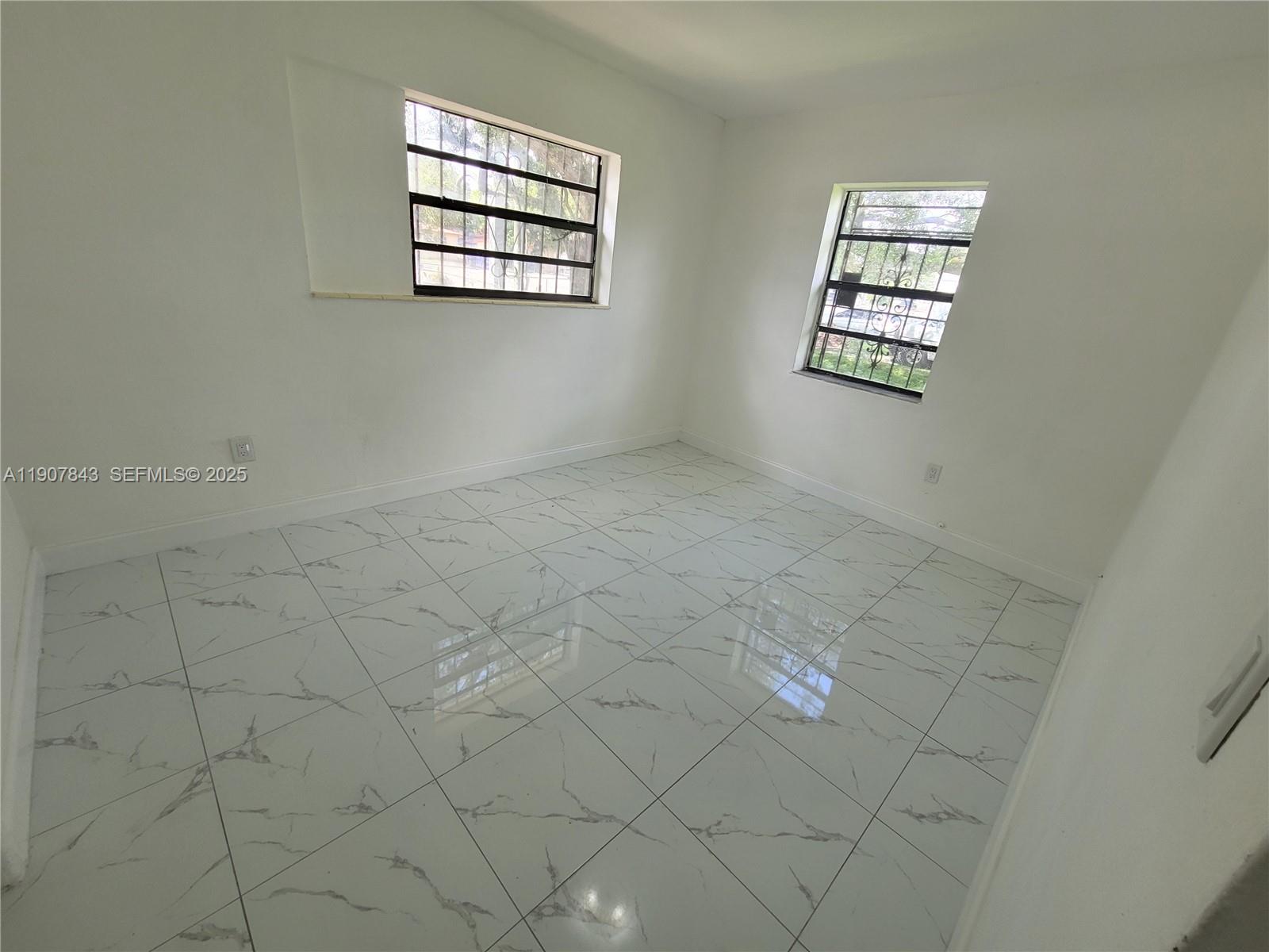 11275 Northwest 17th Avenue Miami, FL 33167 - Photo 20 of 21 an empty room with windows and entrance