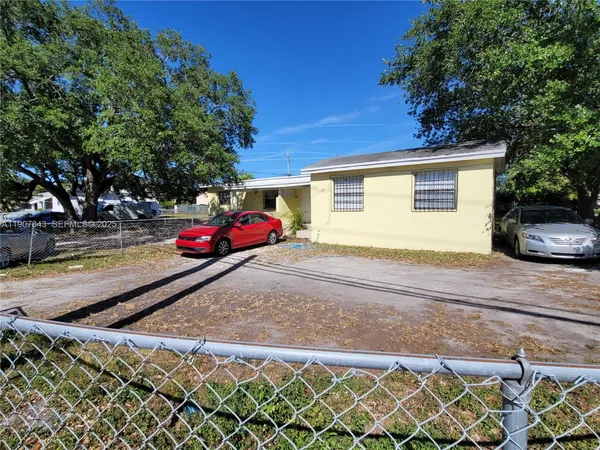 a yellow house with trees in front of it
