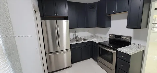 a kitchen with granite countertop a refrigerator stove and microwave