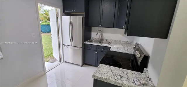 a kitchen with a refrigerator and a stove top oven