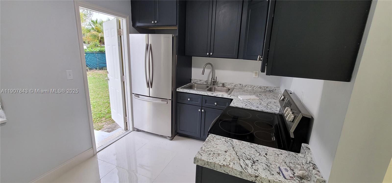 11275 Northwest 17th Avenue Miami, FL 33167 - Photo 8 of 21 a kitchen with a refrigerator and a stove top oven