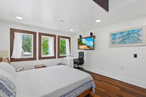 a view of a house with a yard and palm trees