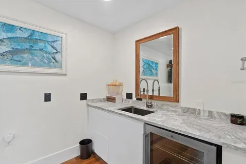 a roof deck with table and chairs and potted plants with wooden floor