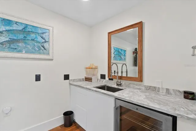 a roof deck with table and chairs and potted plants with wooden floor