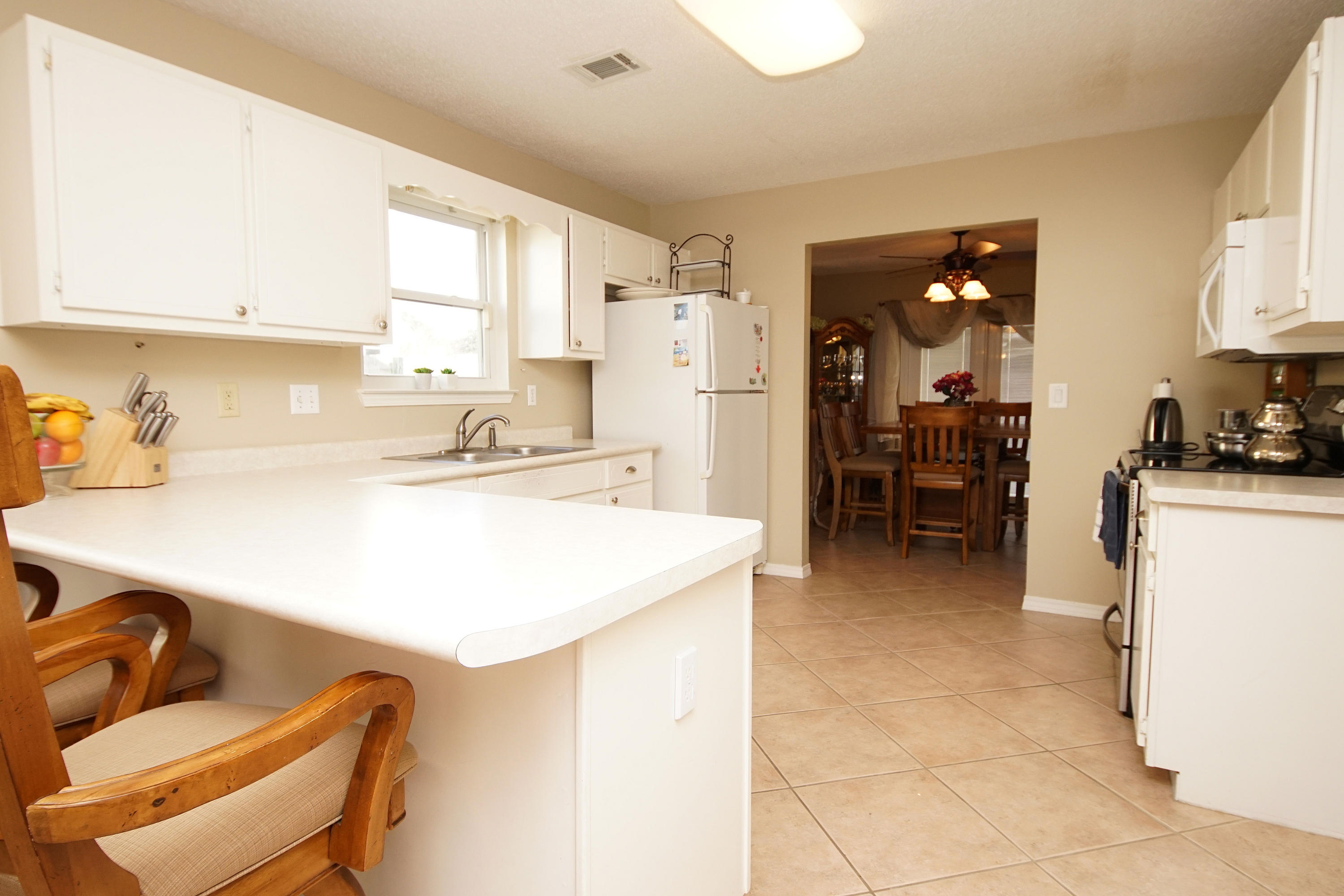 467 Sandy Ridge Circle Mary Esther, FL 32569 - Photo 13 of 37 a kitchen with a sink a stove and chairs