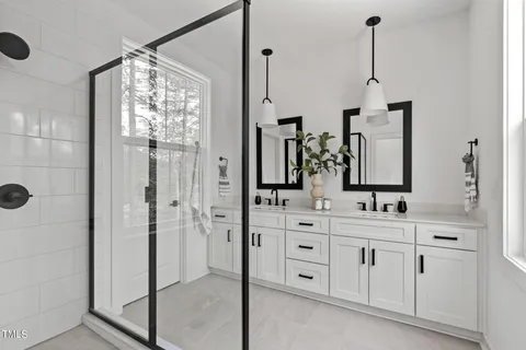 a bathroom with a double vanity sink mirror and shower
