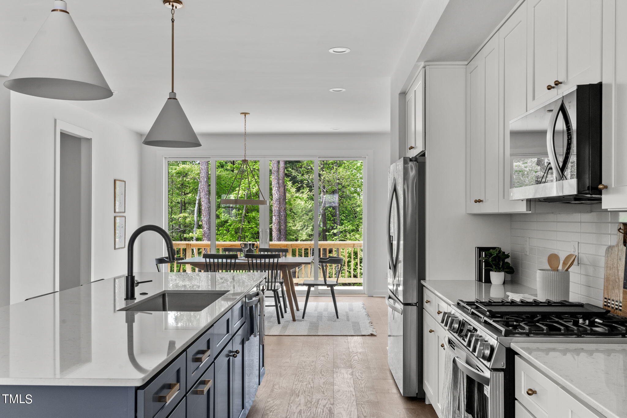 6420 Tanner Oak Lane Raleigh, NC 27613 - Photo 10 of 50 a kitchen with stainless steel appliances a sink a stove a microwave and wooden cabinets