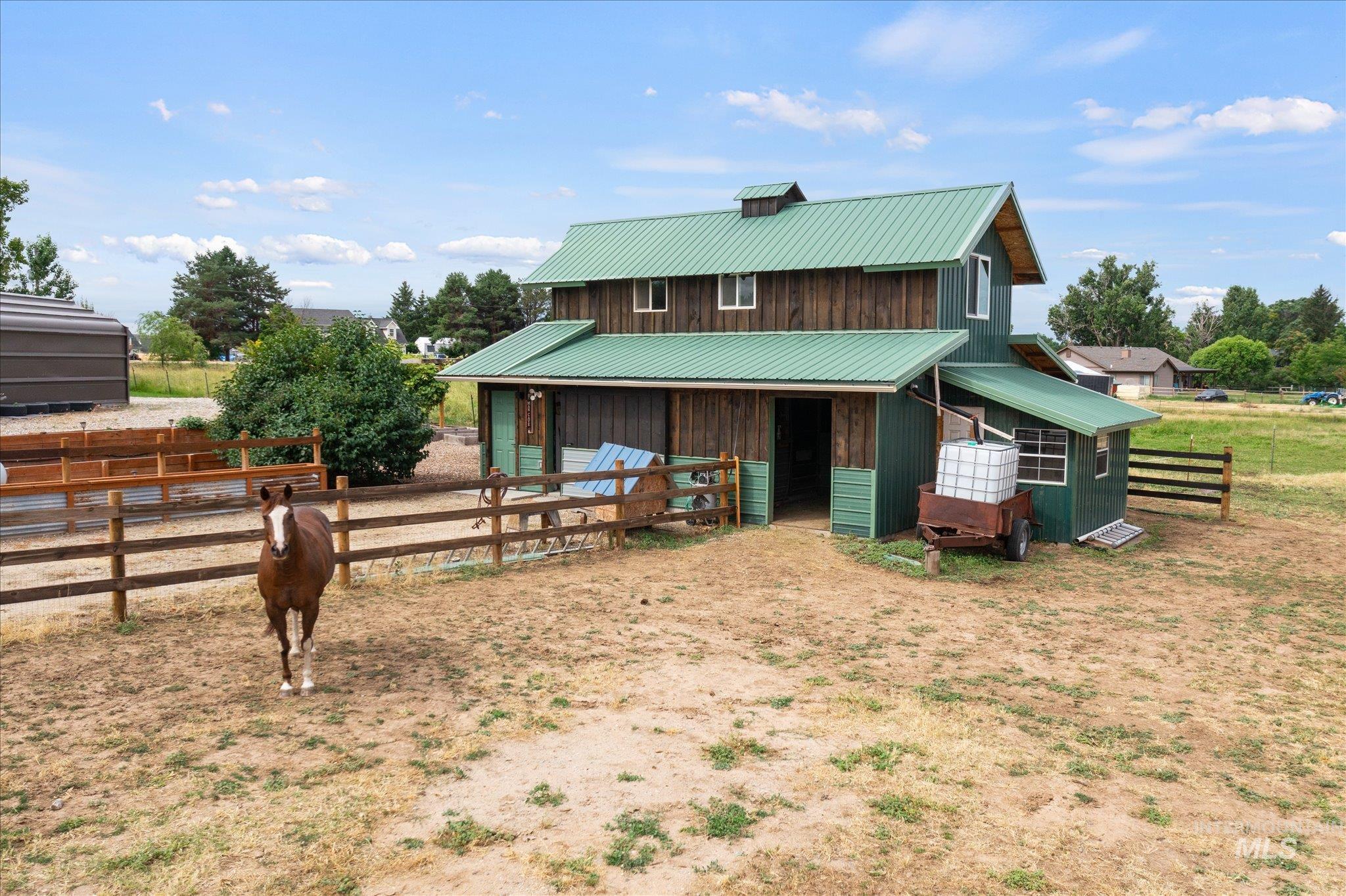 1140 Edgemont Road Emmett, ID 83617 - Photo 44 of 50 Two-story barn structure featuring a green metal roof, natural wood siding, and an attached lean-to shed