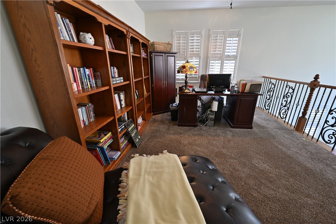 2729 Kildrummie Street Henderson, NV 89044 - Photo 22 of 42 A dedicated home office space with built-in shelving, rich wood desk, and elegant wrought iron railing.