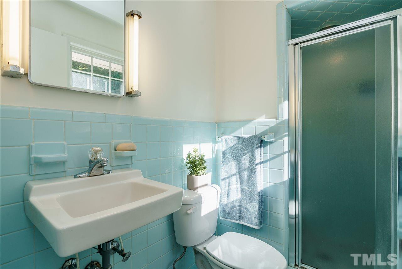 4224 Rowan Street Raleigh, NC 27609 - Photo 18 of 24 a bathroom with a sink a toilet a mirror and shower