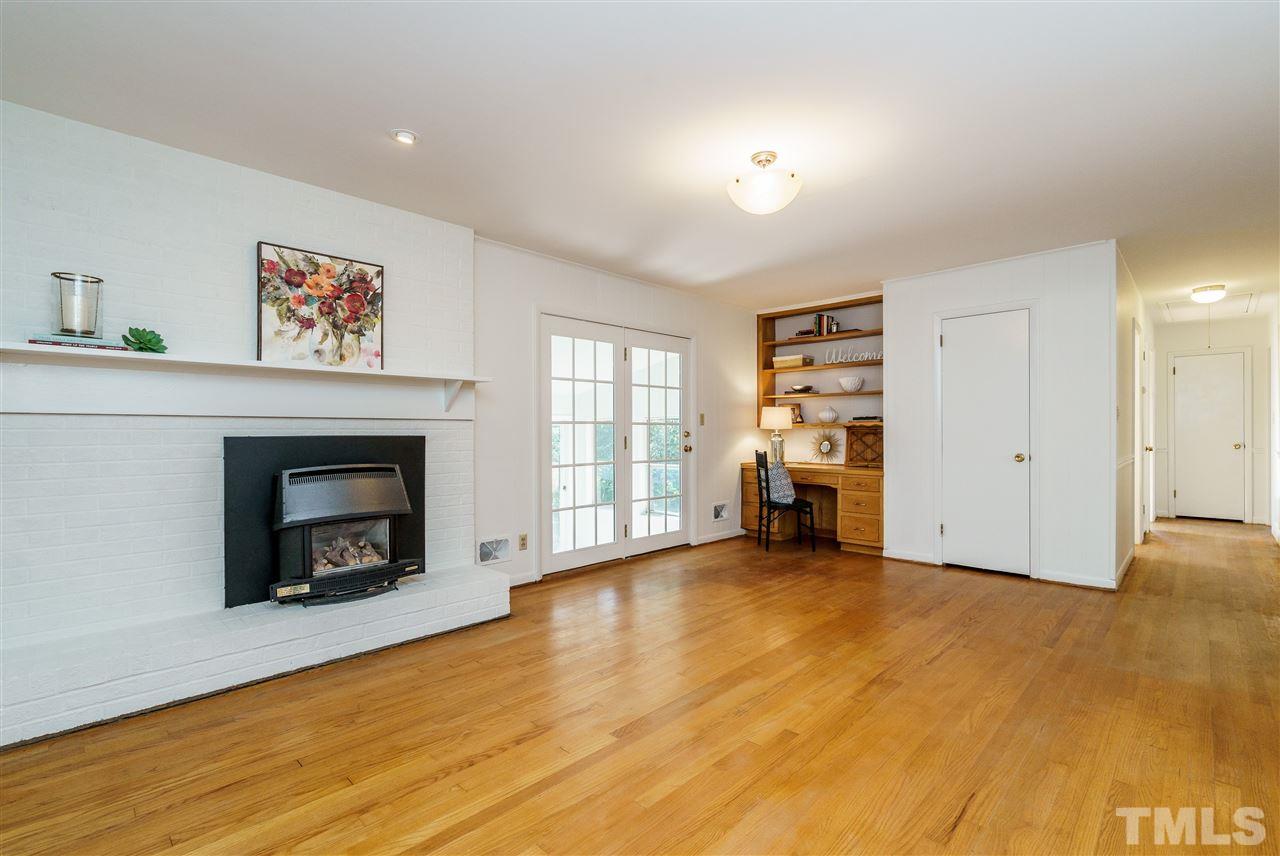 4224 Rowan Street Raleigh, NC 27609 - Photo 8 of 24 a view of an empty room with a fireplace and window