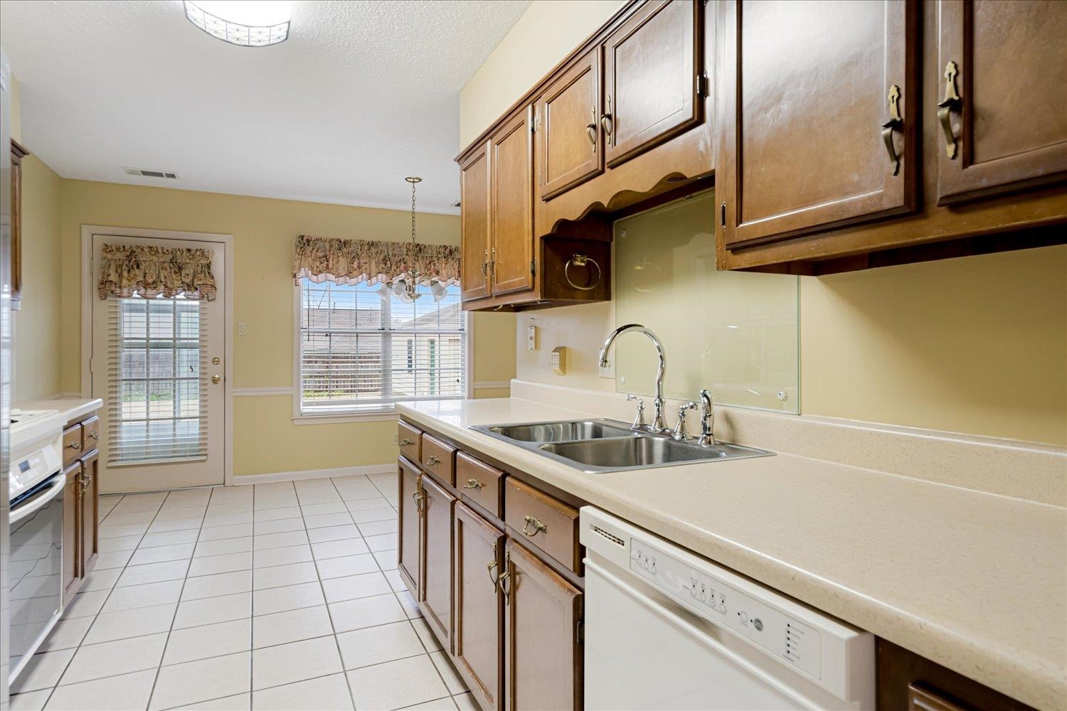 489 Autumn Trail Cove Collierville, TN 38017 - Photo 13 of 30 a kitchen with stainless steel appliances a sink a stove cabinets and a window