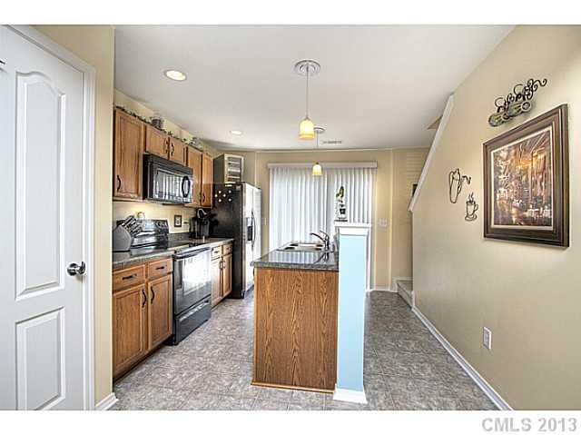 661 Potter Place Road, Unit 106 Fort Mill, SC 29708 - Photo 5 of 16 a kitchen with stainless steel appliances granite countertop a refrigerator a stove top oven a sink dishwasher and wooden cabinets