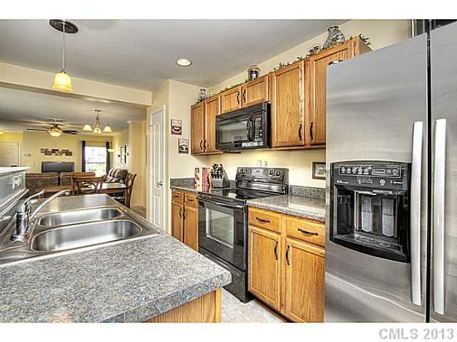 661 Potter Place Road, Unit 106 Fort Mill, SC 29708 - Photo 6 of 16 a kitchen with kitchen island granite countertop a sink stove and refrigerator