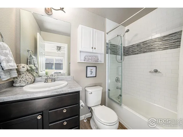 a bathroom with a sink a toilet a mirror and shower